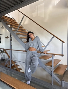 Detail view of a gray knitted two-piece set featuring a zip-up hoodie and wide-leg pants