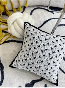 Close-up of black and white woven velvet cushion with thick texture and piping detail