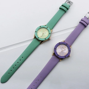 Vintage women quartz watches with green and purple leather straps on a light background