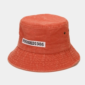 Detail view of FOUNDED1986 embroidery on vintage washed cotton orange bucket hat