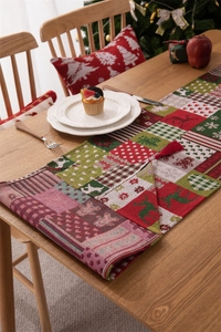 Dettaglio del runner natalizio in tessuto jacquard con renne, fiocchi e nappe eleganti