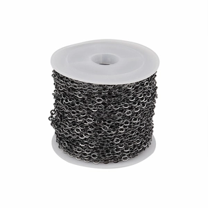 Detail of dark grey flattened O-link chain roll on white spool for DIY jewelry making