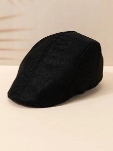 Close-up of black breathable linen flat cap with knitted texture on beige background