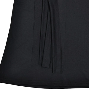 Détail d'une robe noire montrant le drapé froncé latéral et la couture fine de l'ourlet
