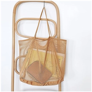 Brown mesh beach tote bag hanging on a wooden chair for stylish summer organization