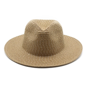 Detailed macro view of beige woven straw hat with shimmering sequins and classic indented crown