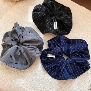 Lot de trois chouchous à rayures avec broderie nœud et étiquette Happiness