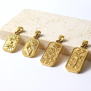 Macro detail of retro gold-plated sun and flower relief charms on a stone surface