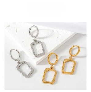 Detail of geometric rectangle earrings with irregular hammered texture in gold and silver