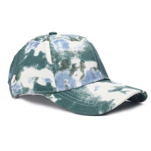 Detailed view of tie-dye baseball cap featuring green and blue cotton twill textures