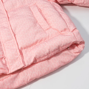Detail einer rosa Baumwolljacke mit weißen geometrischen Mustern und Seitentaschennaht