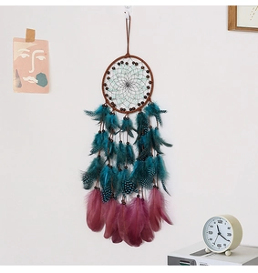 Detailed shot of handmade dreamcatcher with colorful feathers and beads on white wall