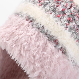 Gros plan du bonnet en maille mohair rose et blanc montrant la texture douce et les fils