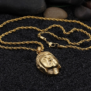 Detailed close-up of golden Buddha head pendant on a twisted rope chain necklace