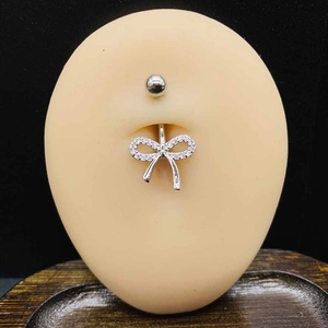Piercing de nombril en acier avec nœud en zircone AAA et pendentif cœur sur modèle