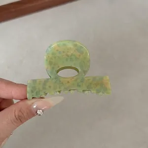 Detail view of 6cm green marble acetate hair claw clip with anti-slip spring teeth design