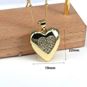 Macro detail of a 19mm gold heart locket necklace with zircon crystals on a wooden stand