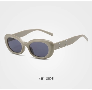 Detail view of cat-eye sunglasses with silver diamond studs on beige temples at 45 degree angle