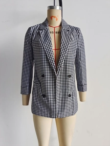 Detail of double-breasted black and white checkered blazer with classic peaked lapels