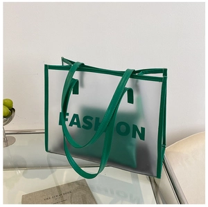 Close-up of emerald green frosted transparent tote bag with FASHION text and inner pouch