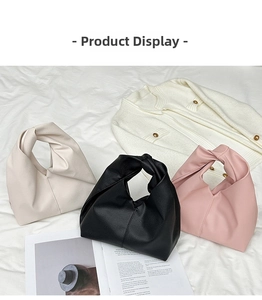 Close-up of minimalist croissant bags in cream, black, and pink with knotted handles
