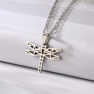 Detailed close-up of a hollow dragonfly pendant necklace in polished silver stainless steel