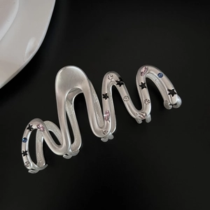 Star-patterned silver wavy hair claw clip with colorful zircon stones on black backdrop