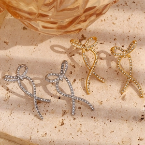Detailed shot of twisted bow earrings in gold and silver plating with sparkling crystals