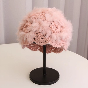 Detail of pink hand-crocheted knit beanie featuring soft rabbit fur trim and floral accents