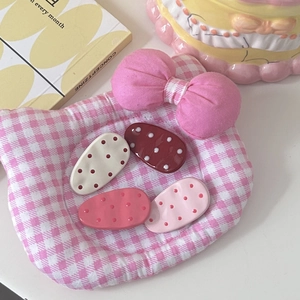 Cute polka dot oval hair clips set in creamy white, dark red and pink on soft cushion