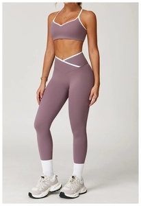 Detail van een high-waist yogabroek met cross-over taille en paarse sport-bh