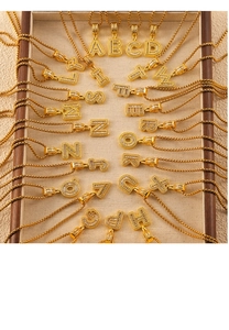 Macro detail of gold-plated box chain necklaces with zircon-studded initial pendants