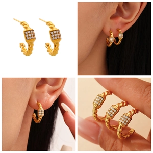 Close-up of gold-plated C-shaped twist earrings with micro-pave cubic zirconia accents