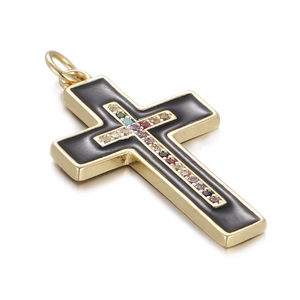 Close-up of golden cross pendant with black inlay and multicolor crystals on white background