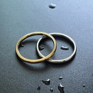 Primer plano de anillos de acero inoxidable en oro y plata con gotas de agua reales