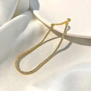 Detail of adjustable gold silver bracelet with sparkling row diamonds and heart tag