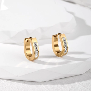 Detail of gold-plated hoop earring with sparkling white zircons and enamel inlay