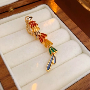 Exquisite gold-plated parrot brooch with colorful rhinestones on a jewelry box display
