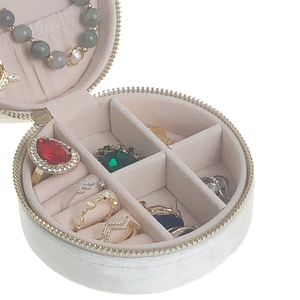 Detail view of round velvet jewelry box with zipper closure and ring slots
