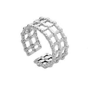 Gros plan sur une bague ajustable en acier inoxydable avec motif grille ajourée