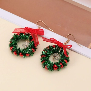 Detailed view of Christmas wreath earrings with red bows and green crystal accents