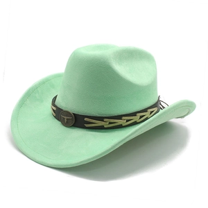 Close-up of mint green suede cowboy hat with vintage bull head emblem and leather band