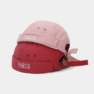 Detail of PARIS embroidered canvas docker hats in pink and dark red with metal buckle