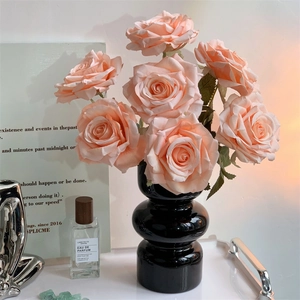 Pink artificial roses in black glass vase for elegant home table floral decoration