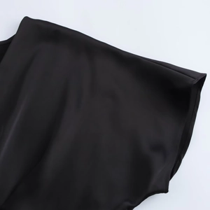 Macro detail of the elegant black satin fabric showing V-neck drapes and smooth texture