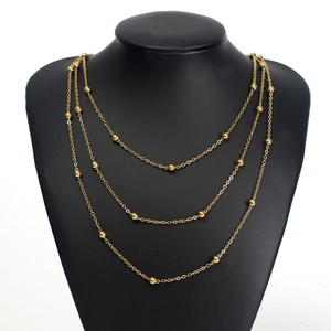 Three-layer gold butterfly stainless steel necklace with small beads on a black bust