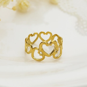 Macro view of gold hollow heart open ring with a polished metallic finish on ceramic
