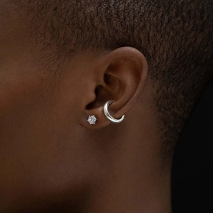 Detailed close-up of a S925 sterling silver moissanite stud earring and ear cuff on ear