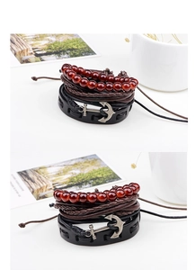 Close-up of vintage multi-layer leather bracelets with silver anchor and wooden beads