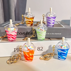 Set of six colorful miniature sundae ice cream cup keychains on a vintage book background